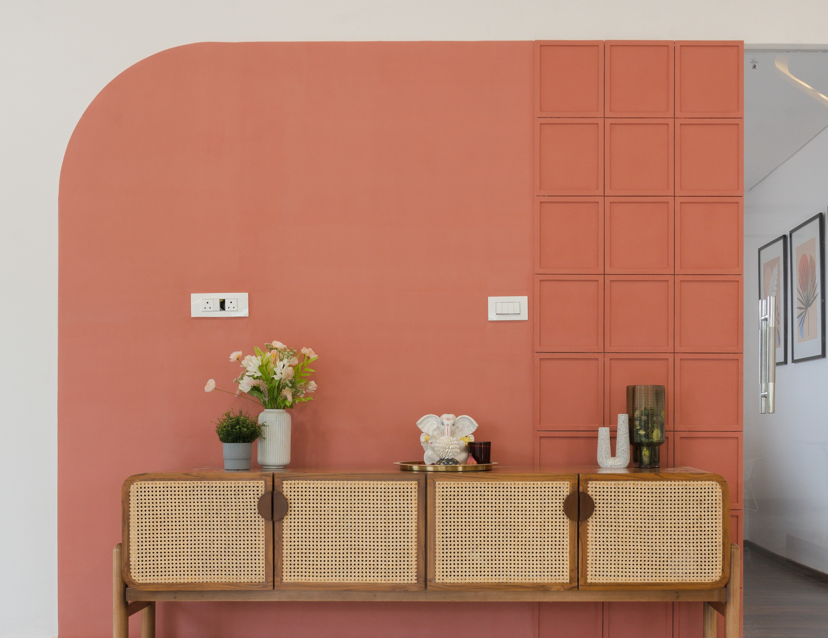 A terracotta feature wall with cane-fronted console
